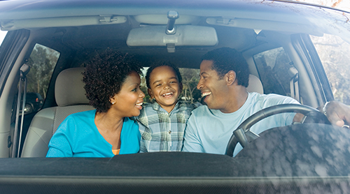 Smiling young family of three inside their car - Free Insurance Quotes - Contact Us now